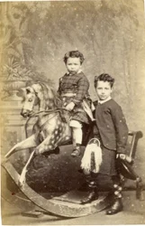 Jong meisje op hobbelpaard met jongen in kilt staand, 1860s