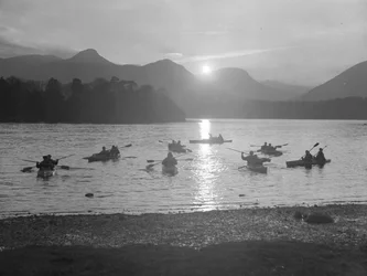 Mensen aan het kanoën op Derwentwater bij zonsopgang of zonsondergang