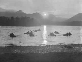 Mensen aan het kanoën op Derwentwater bij zonsopgang of zonsondergang