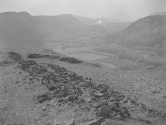 Uitzicht over een open vallei bij Hardknott met rotsblokken op de voorgrond