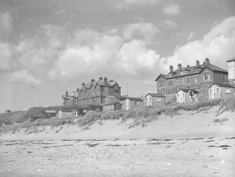 Uitzicht vanaf het strand van Silloth op strandhuisjes en huizen langs zee; zeegezicht;voorkant
