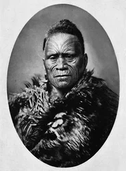 Een Maori-hoofdman met uitgebreid getatoeëerd gezicht en weerjas, 1902