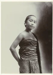 Studioportret van een jonge Javaanse vrouw in een sarong met batik motief