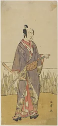 Een acteur in een samurai rol met een bamboefluit