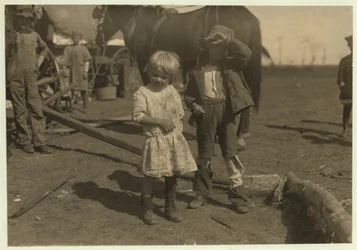 Katoenplukker van 4 jaar die regelmatig 15 pond per dag plukt en 7-jarige die 50 pond plukt. Ze verhuizen van boerderij naar boerderij en wonen in emigrantenwagens, McKinney, Texas, 1913