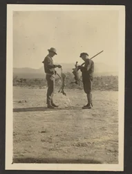 [Fleckenstein and Man Holding Guns and Dead Jackrabbits].