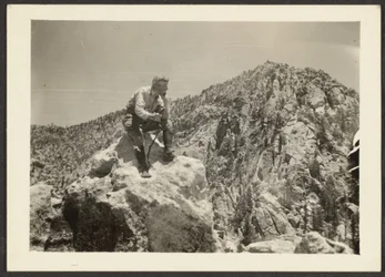 [Man bovenop rotsen].