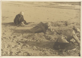 [Drie meisjes die in de winter zandkastelen bouwen]
