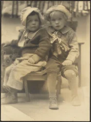 [Twee kinderen delen stoel]
