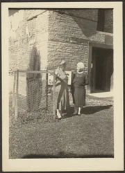 [Twee vrouwen voor het gebouw].