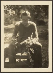 [Vrouw die zonnebloemen vasthoudt].