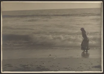 Vrouw die in de branding op het strand loopt