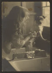 Vrouw die een hond in de gootsteen wast