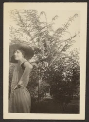 [Vrouw met hoed in boomgaard].