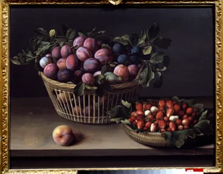 Een perzik, aardbeien en een mand met fruit