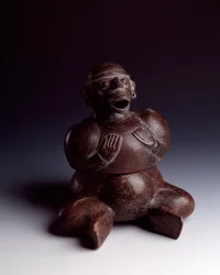 Precolumbiaanse kunst, Mayabeschaving, vroege periode: antropomorfe vaas van klei met een zittende man die zijn handen op zijn borst houdt en een apenmasker met open mond draagt. Uit Uaxactún, Guatemala. Afmetingen: h. 22,5 x b. 19 cm. Guatemala