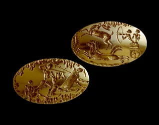 Myceense kunst: twee gouden zegels met de voorstelling van een jachttafereel op een tank en een krijger die tegenover drie tegenstanders staat. 1550-1100 v.Chr. uit graf IV in Mycene. Nationaal Archeologisch Museum van Athene (inv. 240 en 241)