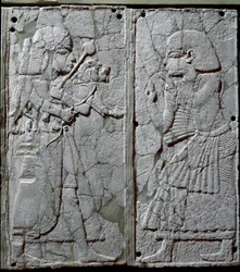 Fenicische beschaving: bedornament versierd met een ivoren bas-reliëf waarop een bewaker een leeuw aan de koning presenteert. Afkomstig van de vindplaats Ugarit, een oude Syrische stad op Tell Ras Shamra. 14e eeuw v.Chr. Afmetingen 24 cm. Damascus