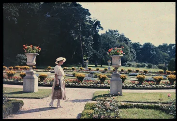 Wandelende vrouw in de tuin van de Bagatelle, Parijs, ca.1920 (foto)