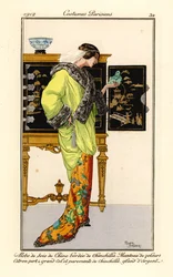 Vrouw in zijden jurk met chinchilla versiering, citroengroene fluwelen cape met chinchilla kraag en manchetten, met een jade boeddha. Chinees kabinet op de achtergrond. Robe de soie de chine bordee de chinchilla, manteau de velours citron vert a grand col 