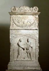 Romeinse kunst: grafaltaar versierd met een huwelijksscène (Junctio dextrarum). Laag reliëf. Rome, Museo Nazionale Romano. Huwelijkse handdruk (Junctio dextrarum). Marmeren reliëf, Romeinse kunst, van het grafaltaar van een echtpaar. Rome, Museo Nazionale
