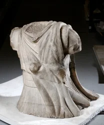 Gebeeldhouwd torso van een ruiter met zwaar versleten mantel