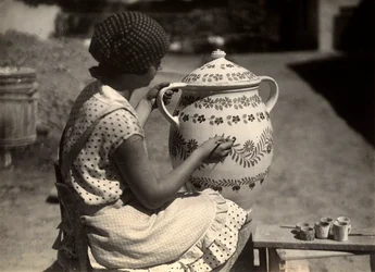 Een Hongaarse dame geportretteerd terwijl ze een amphora schildert met bloemmotieven; naast haar, op een kleine bank, de kwasten en de glazen met de kleuren
