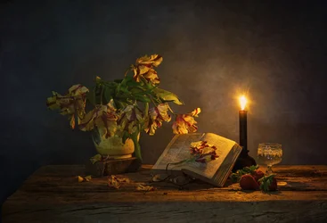 Boek en bloemen bij kaarslicht