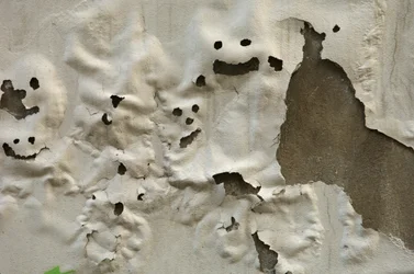 Italië, Toscane, Florence, Lachende spookgezichten op verweerde geschilderde muur, 2022 (foto)