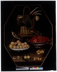 Een stilleven met granaatappels en druiven in een mand