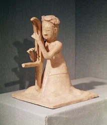 Zittende muzikant die een harp speelt