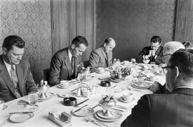 Zakenlieden bidden voordat ze beginnen met lunchen tijdens een fondsenwervingsbijeenkomst in een kerk