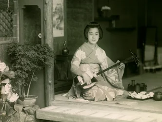 Portret van een Japanse vrouw spelend op de shamisen circa 1900 - 1915 (foto)