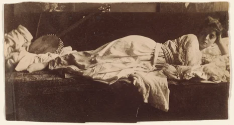 Blanche Gilroy in klassiek kostuum, liggend met banjo