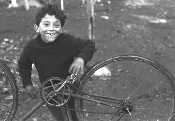 Kind dat een fiets repareert, Borghetto Nomentano, Rome, Italië