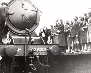Kinderen kijken naar een stoomlocomotief, 3 maart 1936