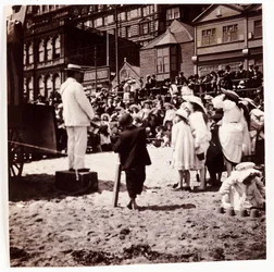Menigte die naar een strandartiest kijkt, ca. 1905