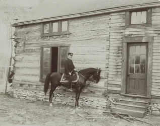 Generaal Frederick Dent Grant te paard voor de hut (Hardscrabble) gebouwd door zijn vader, Ulysses S. Grant