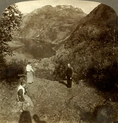 Hooien op bergplateau hoog boven het dorp Marok en spiegelhelder Geirangerfjord, Noorwegen, ca. 1905