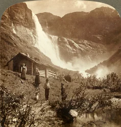 Eenvoudig bergthuis aan de voet van kliffen waar de Skiaeggedals-waterval 525 ft. valt, Noorwegen, ca. 1905
