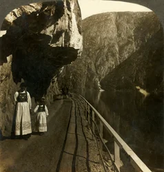 Smal rotsplateau waar de weg naar Voring Falls langs het diepe water van het Oifjord-meer, Noorwegen, ca. 1905