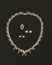 Art Deco ketting met rol- en bladontwerp; robijn- en diamantbaguettring; saffier- en diamantdriesteenring; smaragd- en diamantdriesteenring