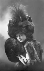 Mode: een jonge vrouw in bont (jas, verenhoed en mouw). Jaren 1920-1930 Historische modefoto, vrouwelijk model