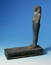 Ptah-Sokar-Osiris figuur met tripartiet pruik en gekruiste armen op een rechthoekige sokkel met een compartiment met een stuk papyrus, Egyptisch, 21e-22e Dynastie, c.900 v.Chr.