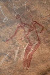 Rotstekeningen, Prehistorie: Rotsschildering van twee langgerekte figuren in een versierd onderkomen in de Uweinat-bergen, Soedan. Fotografie