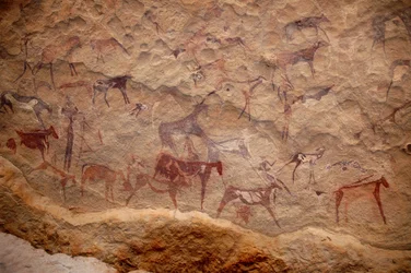 Rotstekeningen, Prehistorie: Rotsschildering van een groep runderen en polychrome personages (herders en boogschutters) in een versierd onderkomen, in het Uweinat-massief, Soedan. Periode van 8000 tot 3000 jaar v.Chr. Fotografie