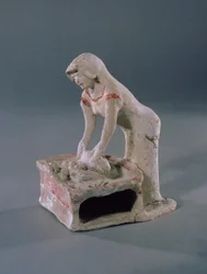 Vrouw die brood kneedt op een vierkante plaat, Grieks, uit Aulis, c.500-475 v.Chr. (klei met witte slip en rode pigment)