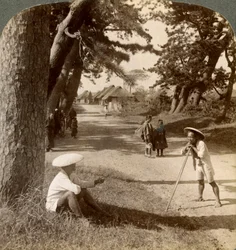 Reizigers rustend onder de pijnbomen bij Suzukawa, oude postweg van Tokio naar Kyoto, Japan, 1904