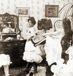 Stereoscopische kaart die een vrouw toont die in een korset wordt geregen, c.1900