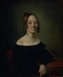 Portret van een meisje in een zwarte jurk zittend aan tafel